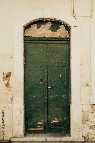 Old green wooden door in old abandoned bulding in Gibraltar. © PirahaPhotos