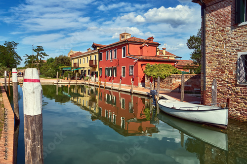 Torcello, Venice. Colorful houses on Torcello island, canal and boats. Summer, Italy
