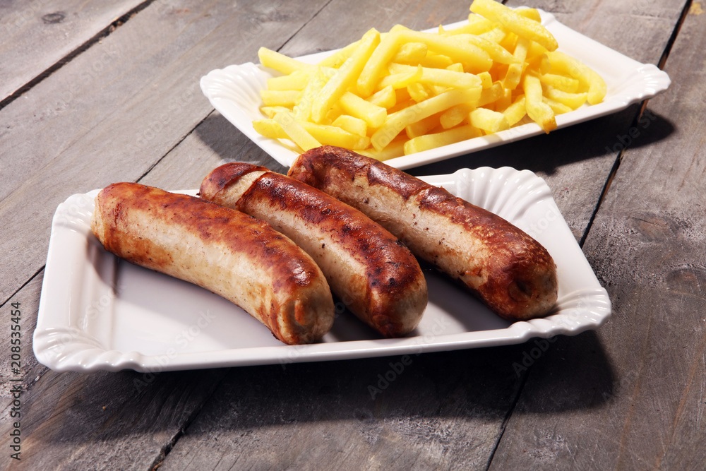 Grilled sausage served with french fries or fried potatoes with sausage Grilled sausage served with french fries or fried potatoes with sausage