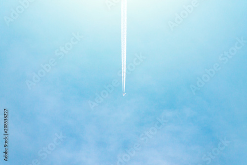 An Airplane with contrail high in the sky, two turbine aircraft flying high in the blue sky photo