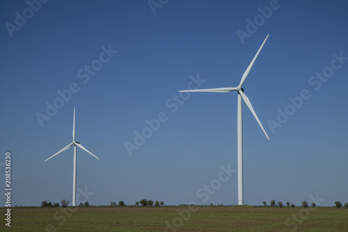 Wind energy turbines on sunset sky background, Energy generator nature friendly. Spring field.