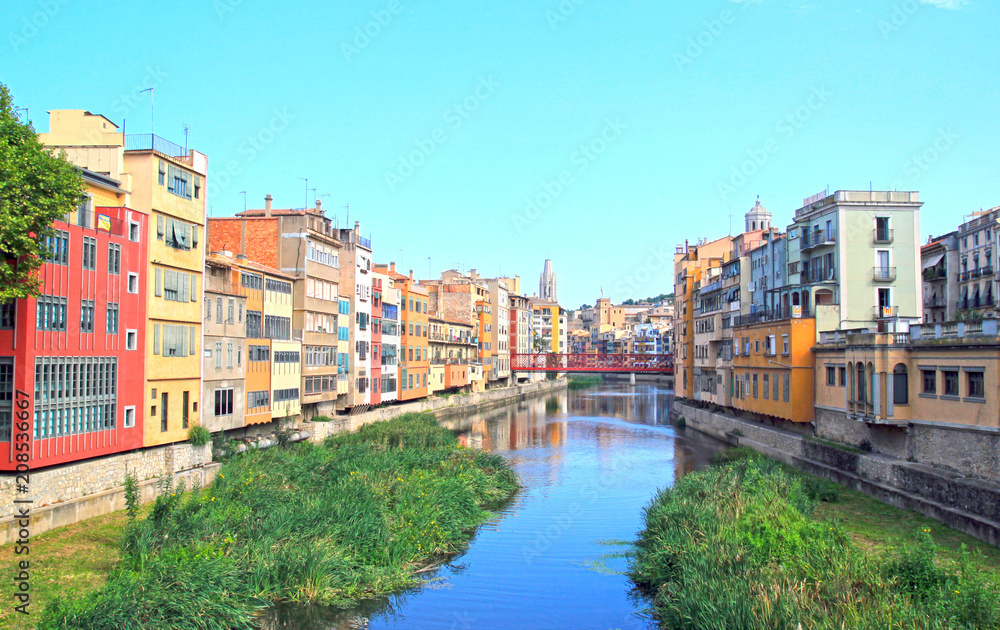 Colorful houses on both sides of the river Onyar. Red bridge. Beautiful town of Girona, Catalonia, Spain.