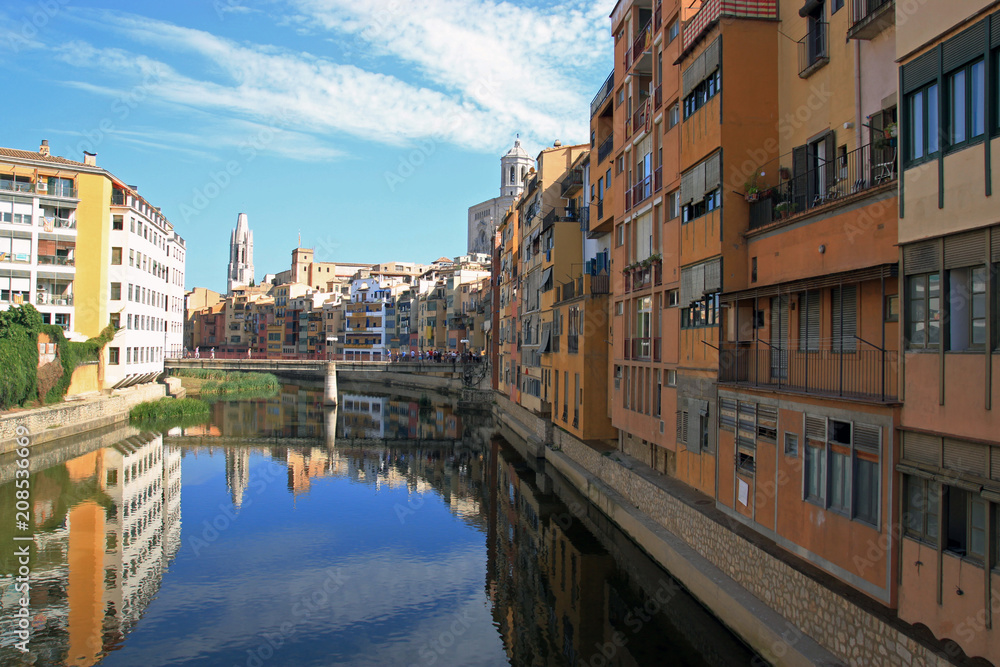 Colorful houses reflected in the water of the river Onyar. Beautiful town of Girona, Catalonia, Spain.