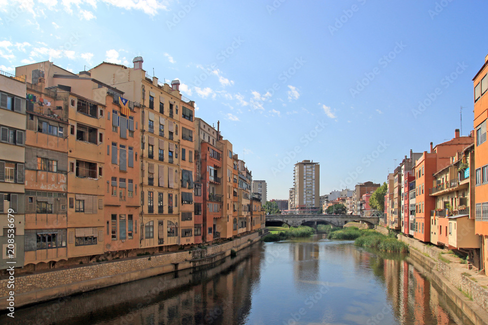 Colorful houses reflected in the water of the river Onyar. Beautiful town of Girona, Catalonia, Spain.