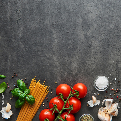 Food background for tasty Italian dishes with tomato. Various cooking ingredients with spaghetti. Top view, square crop with copy space.