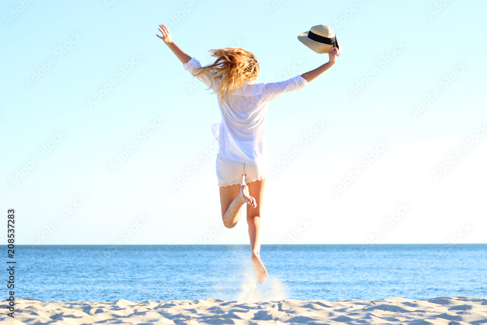 the girl is jumping against the sea. the girl is jumping against the sea.
