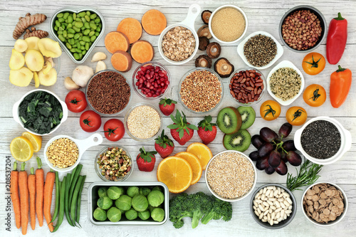 Fresh super food concept with fruit, vegetables, grains, cereals, pulses, seeds, herbs and spice. Foods high in fibre, anthocyanins, antioxidants, smart carbohydrates, minerals and vitamins.