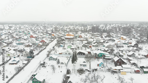 Smooth aerial shot above winter snowy forest, cold russian weather. Opening forward moving view at countryside village. © railwayfx