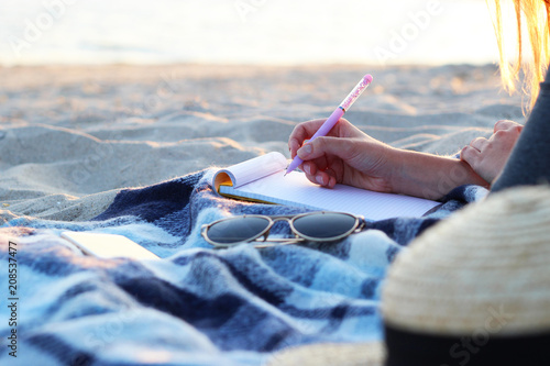 Canvas Print girl with a paper notebook by the sea works. freelancing