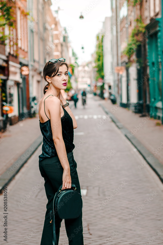 portrait of a beautiful fashionable young girl in the streets of Amsterdam, the Netherlands in the spring evening