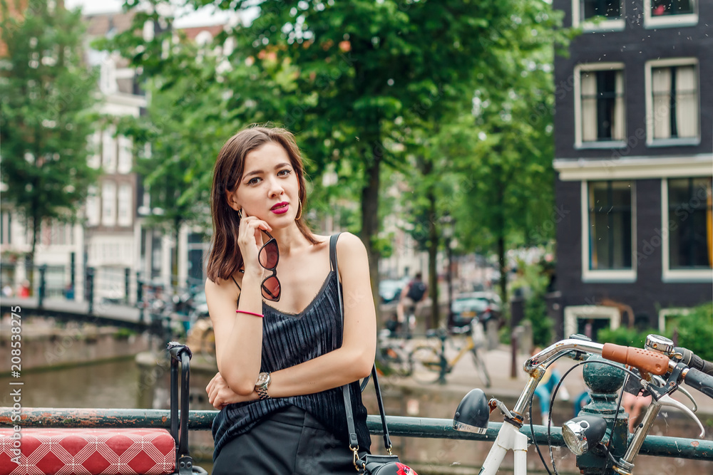 portrait of a beautiful fashionable young girl in the streets of Amsterdam, the Netherlands in the spring evening