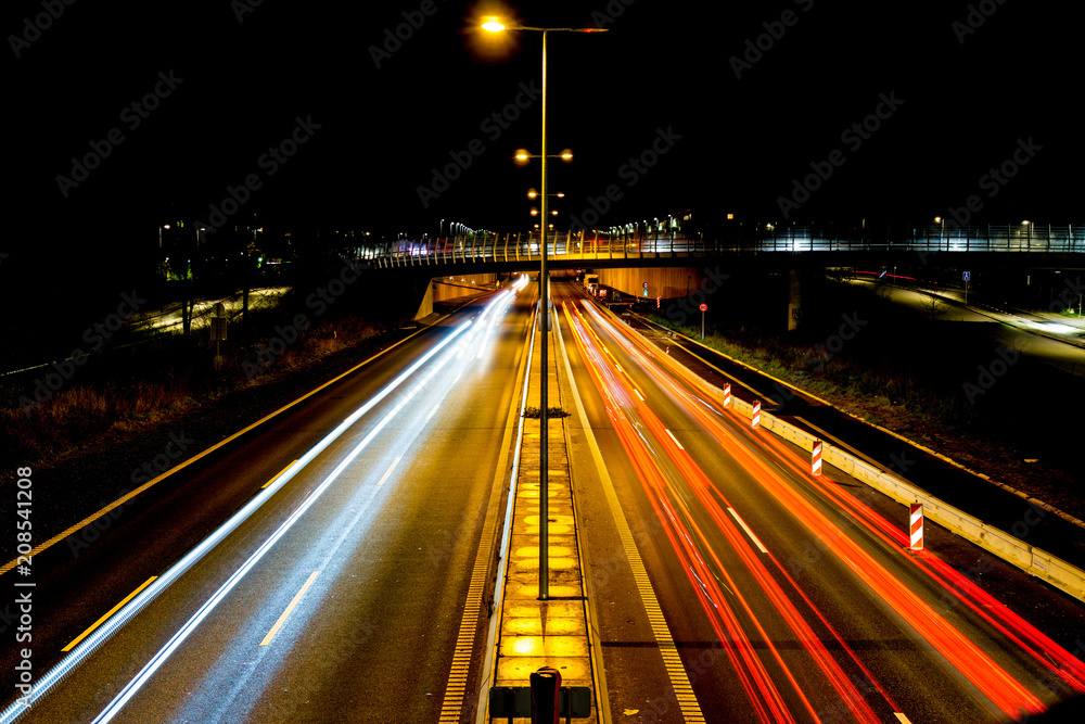 Light trails, city lights and traffic lights on a highway that leads into the city centre of Copenhagen in Denmark. Taken from a bridge near a train station named Ryparken.