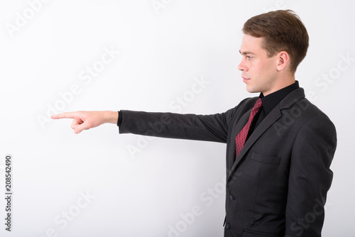 Young handsome businessman wearing suit against white background