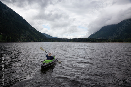 Adventurous Man on a Kayak is enjoying the beautiful Canadian Mountain Landscape. Taken in Jones Lake, near Chilliwack and Hope, East of Vancouver, BC, Canada.