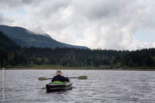 Adventurous Man on a Kayak is enjoying the beautiful Canadian Mountain Landscape. Taken in Jones Lake, near Chilliwack and Hope, East of Vancouver, BC, Canada.