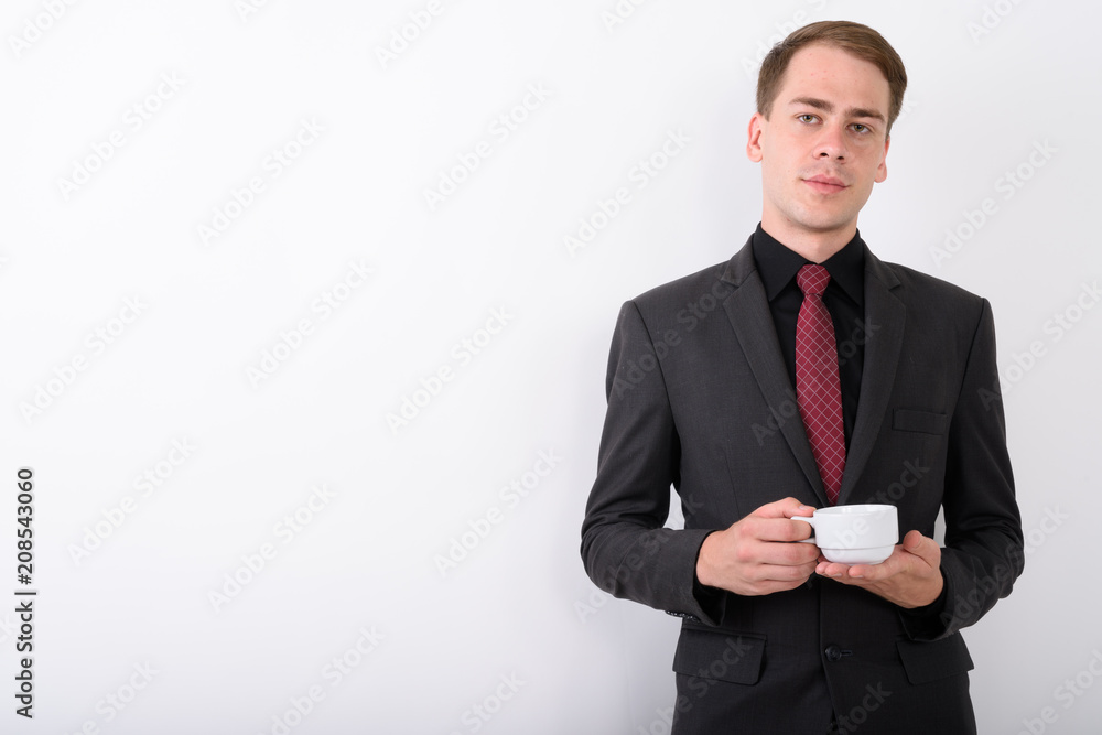 Young handsome businessman wearing suit against white background Young handsome businessman wearing suit against white background