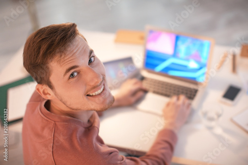 Young man working with laptop indoors