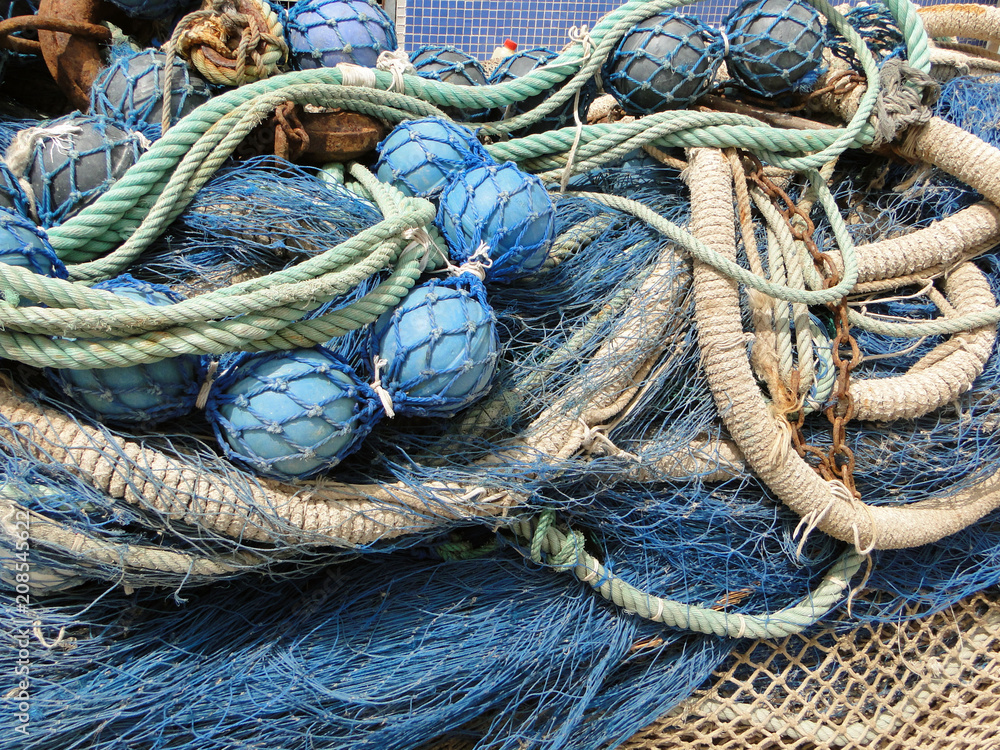 fishing nets rolled up with blue buoys ropes