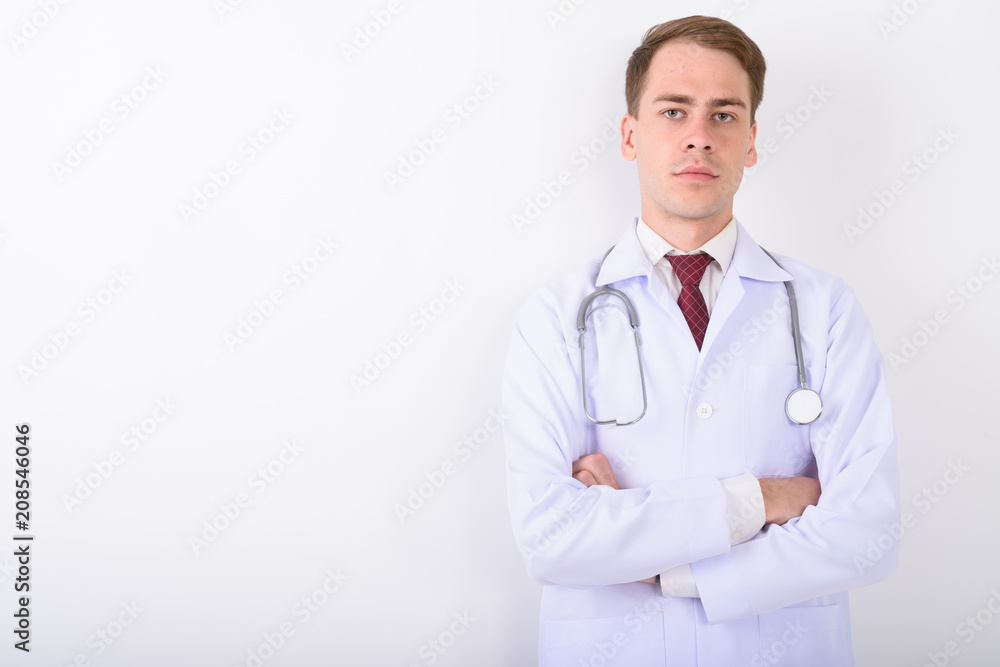 Young handsome man doctor against white background Young handsome man doctor against white background