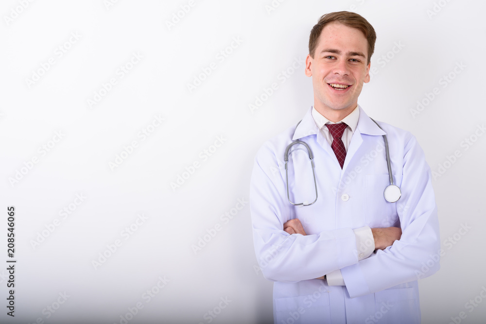 Young handsome man doctor against white background Young handsome man doctor against white background