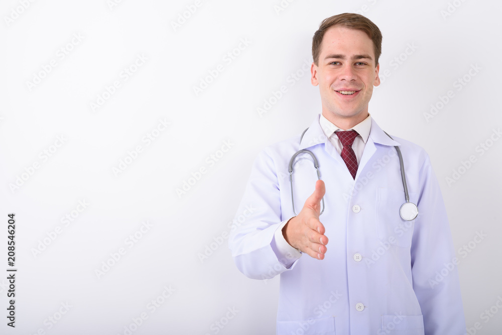 Young handsome man doctor against white background Young handsome man doctor against white background