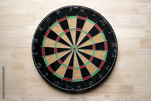 Target dart board on the wooden table background, center point, head to target marketing and business concept