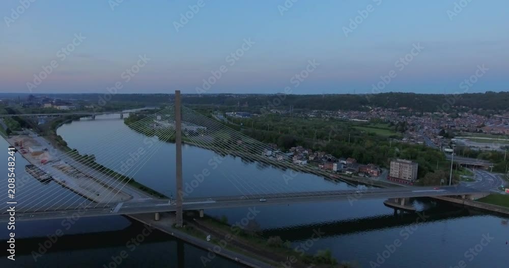 Aerial view of steel cable bridge crossing in Belgium. Road in perspective. European bridge over a river at sunset. Aerial view of steel cable bridge crossing in Belgium. Road in perspective. European bridge over a river at sunset.