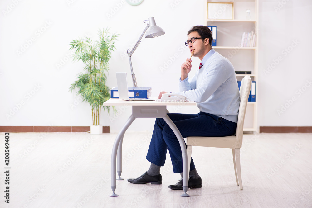 Young handsome businessman employee working in office at desk Young handsome businessman employee working in office at desk