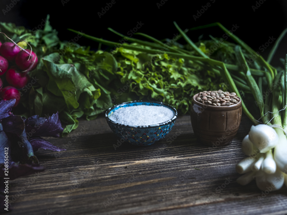close up assortie of herb, salt cup and lentils on dark background close up assortie of herb, salt cup and lentils on dark background