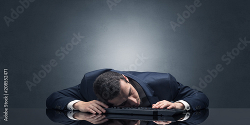 Young businessman fell asleep at his workplace with copy space