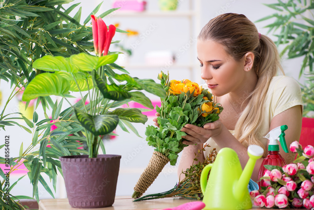 Young woman watering plants in her garden Young woman watering plants in her garden