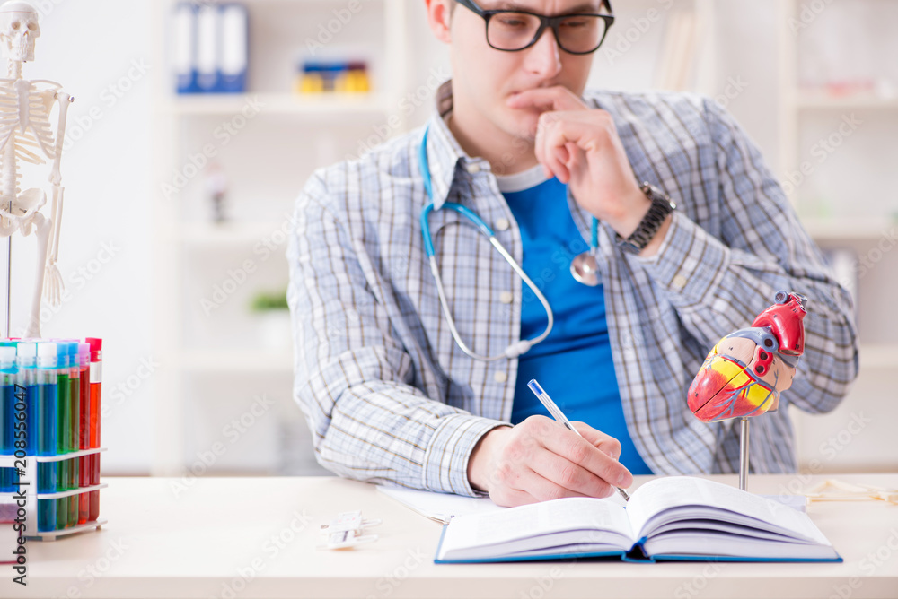 Medical student studying heart in classroom during lecture Medical student studying heart in classroom during lecture