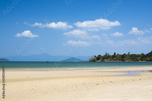 Sand beach with green sea water and blue sky. Islands in Andaman Sea, Thailand.