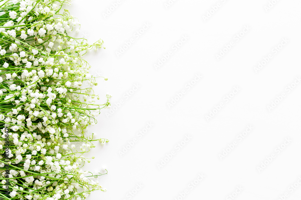 Lily of the valley flowers frame. Spring background on white desk top view copy space Lily of the valley flowers frame. Spring background on white desk top view copy space