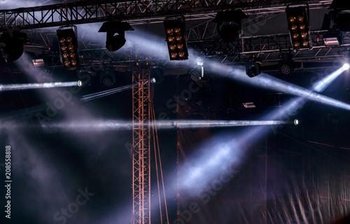 stage during performance. lights of projectors, searchlight rays over stage