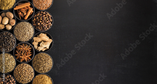 Fototapeta Naklejka Na Ścianę i Meble -  European spices in vintage style, top view. seasoning on  black table with space for  recipe