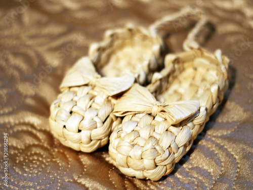 Old Russian sandals made of bark on a golden background