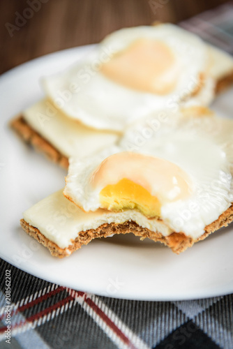 Healthy sandwiches with soft cheese and egg on crisp rye bread on dark wooden background. Breakfast or snack.