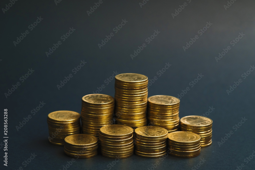 Savings, increasing columns of coins, piles of coins arranged as a graph in dark room, business banking concept. Savings, increasing columns of coins, piles of coins arranged as a graph in dark room, business banking concept.