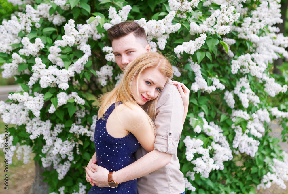 Closeup portrait of a beautiful young couple on the background of the cherry blossoms Closeup portrait of a beautiful young couple on the background of the cherry blossoms