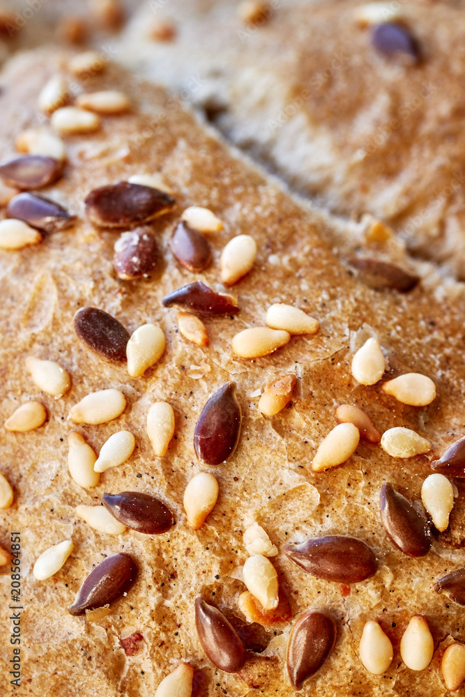 Close up picture of a whole wheat bread crust with flax and sesame seeds, selective focus. Close up picture of a whole wheat bread crust with flax and sesame seeds, selective focus.