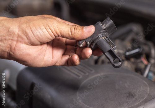 Check air flow meter automobile engine by car technician.