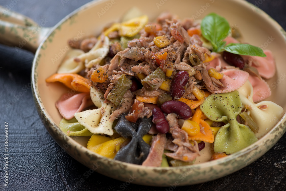 Farfalle pasta with tuna fillet, red beans and corn in a serving pan, selective focus, close-up Farfalle pasta with tuna fillet, red beans and corn in a serving pan, selective focus, close-up