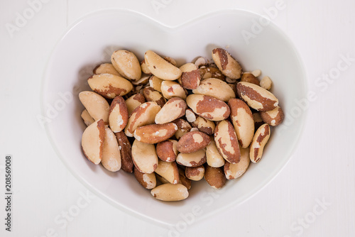 brasil nuts in white heart shape bowl