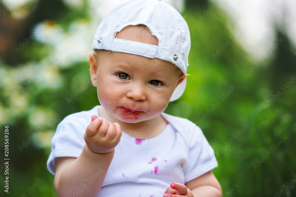 Sweet little child, baby boy, eating cherries in garden, enjoying tasty fruit Sweet little child, baby boy, eating cherries in garden, enjoying tasty fruit