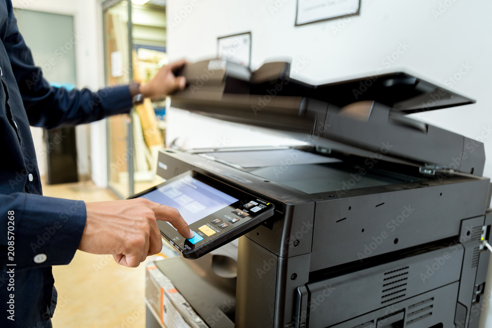 Bussiness man Hand press button on panel of printer, printer scanner laser office copy machine supplies start concept. Bussiness man Hand press button on panel of printer, printer scanner laser office copy machine supplies start concept.