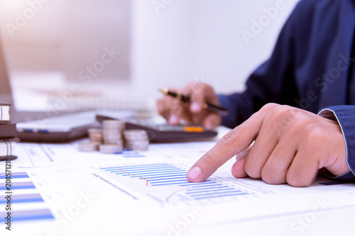 Midsection Of Businessman Calculating Tax Using Calculator In Office.