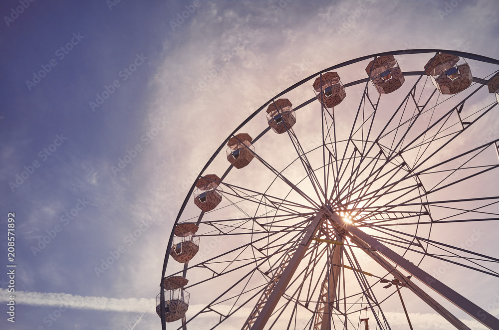 Vintage toned picture of a Ferris wheel at sunrise.