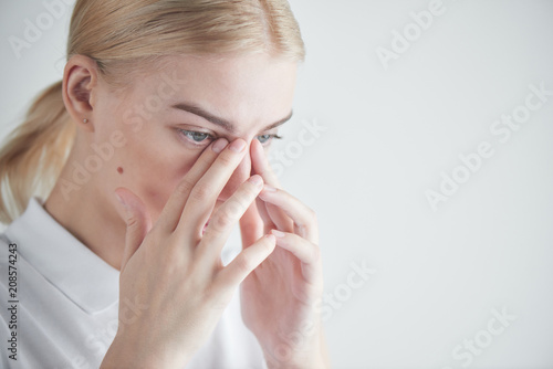 Disease. Eye problems. Girl holding hands near eyes on white background