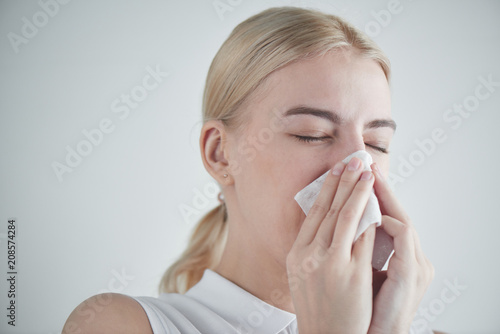 Rhinitis. Girl with napkin on white background